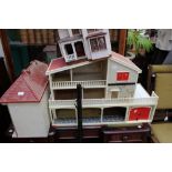 A two part dolls house, unfurnished, balcony and garage, another dolls house, white and brown,