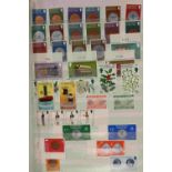 An accumulation of stamps, loose and in packets/albums, within a cardboard box,