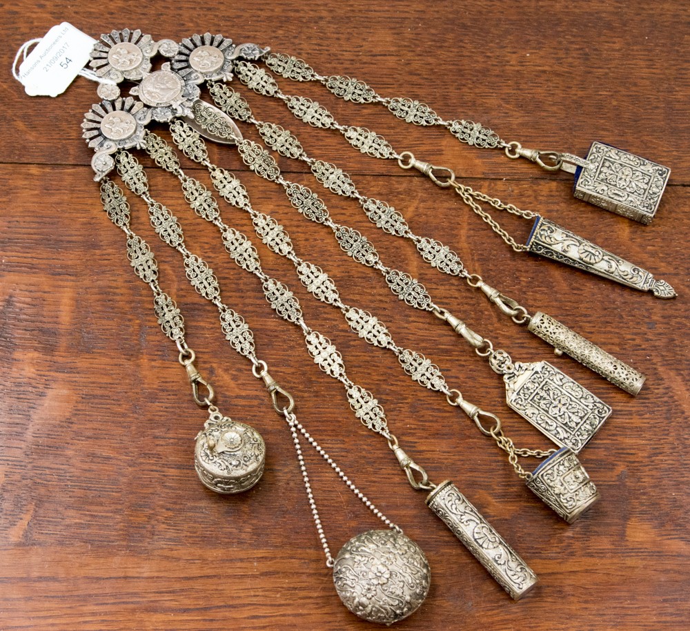 A circa 1900 Continental Chatelaine, in white metal with eight accessories, including a needle box,