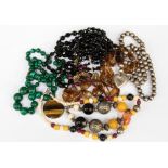 A collection of bead necklaces including malachite, a quartz strand,