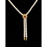 A pearl necklace with a ruby and diamond detail,