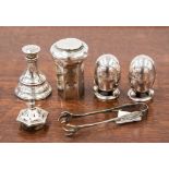 A collection of four silver and white metal peppers;