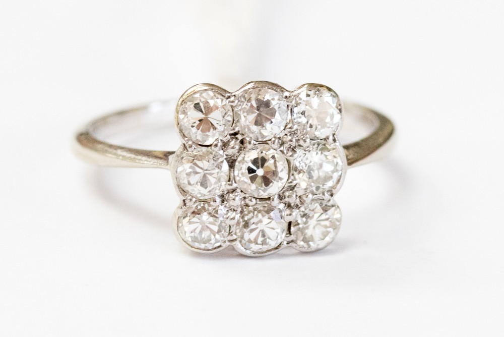 A diamond floodlight unmarked white gold ring, nine round old cut diamonds bead and rub over set,