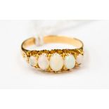 An 18ct gold boat ring, set with five opals, size Q,