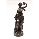 A large bronze figure of a woman with grapes,