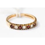 A 9ct gold half eternity ring, claw set with alternate garnets and white stones, size M,