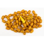 A bag of loose butterscotch amber type beads, each bead measuring approx 23 mm by 13 mm,
