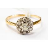 A diamond cluster ring, central stone and six satellite stones on 18ct gold,