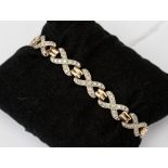 A 9ct and diamond cross motif bracelet, each cross is grain set with diamonds and gold bar links,