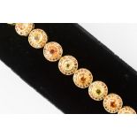 A yellow and orange sapphire and Cognac diamond bracelet, comprising 18ct gold round links,