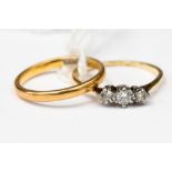 A 22ct yellow gold band, along with a three stone diamond ring,