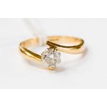 A diamond solitaire 18ct gold crossover ring, the round brilliant claw set diamond approx 0.