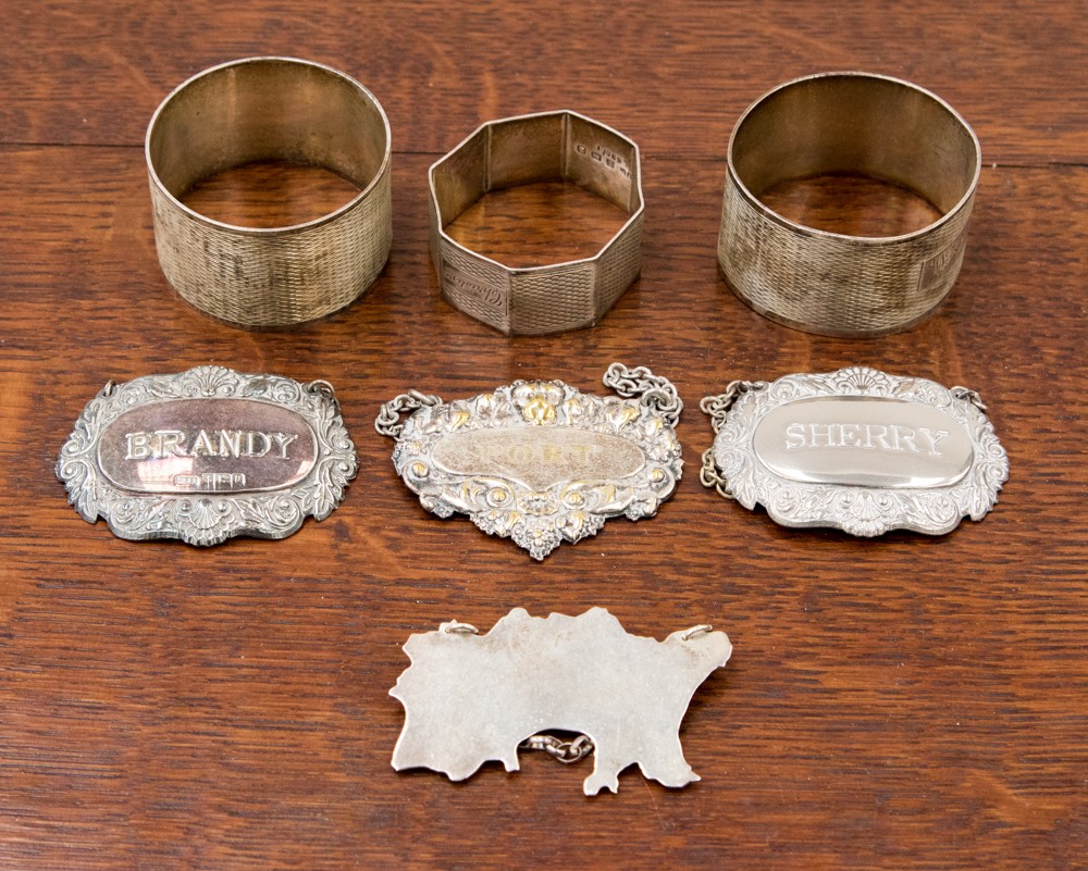 An Australian map wine label, Brandy wine label and three napkin rings 3.36 troy oz approx, 104.