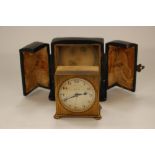 A Zenith circa 1920s cased travel alarm clock, having engine turned gilt metal decorated casing,