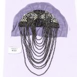 A 1920s headwear embellishment, in the flapper style, grey metallic,