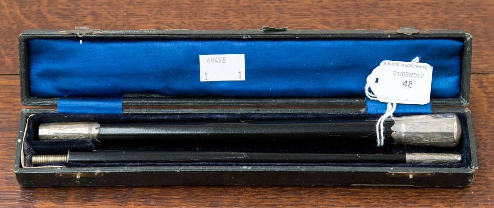 A cased conductors baton, ebonised with silver finial ad tips,