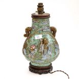 A Japanese twin handled lamp base having raised figures to the body,