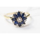 A sapphire and diamond cluster ring with marquise cut sapphires in a flower shape with a round