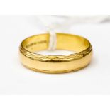 An 18ct gold band, with engraved edges, size V, weight approx 5.