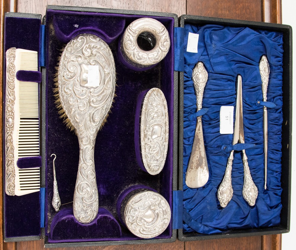 A George V silver toilet set, in leather case, embossed foliate scroll design, including brush,