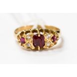 An 18ct ring set with three rubies and four diamond chips, size L1/2,