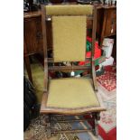 An early 20th Century oak rocking chair, having a padded back, spindle gallery,