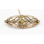 An Edwardian 9ct gold bar brooch set with seed pearls and a peridot,