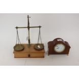 A pair of brass weighing scales, weights in troy oz included, with a mantle clock,