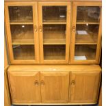 An Ercol Windsor light elm and ash bookcase on cupboard, three bays,