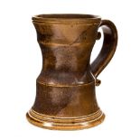 Leo Bonnasera, a Rye studio pottery mug, circa 1970s, waisted form with strap handle, brown glazed,