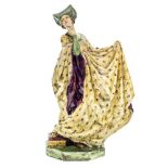 An Art Pottery figure of a PreRaphaelite woman in medieval costume,