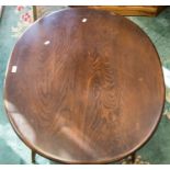 An Ercol dark elm and ash coffee table, oval form on shaped legs, united by a low dowelled shelf,