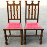 G M Ellwood, attributed, a pair of Arts and Crafts oak chairs, pierced heart motif backs,