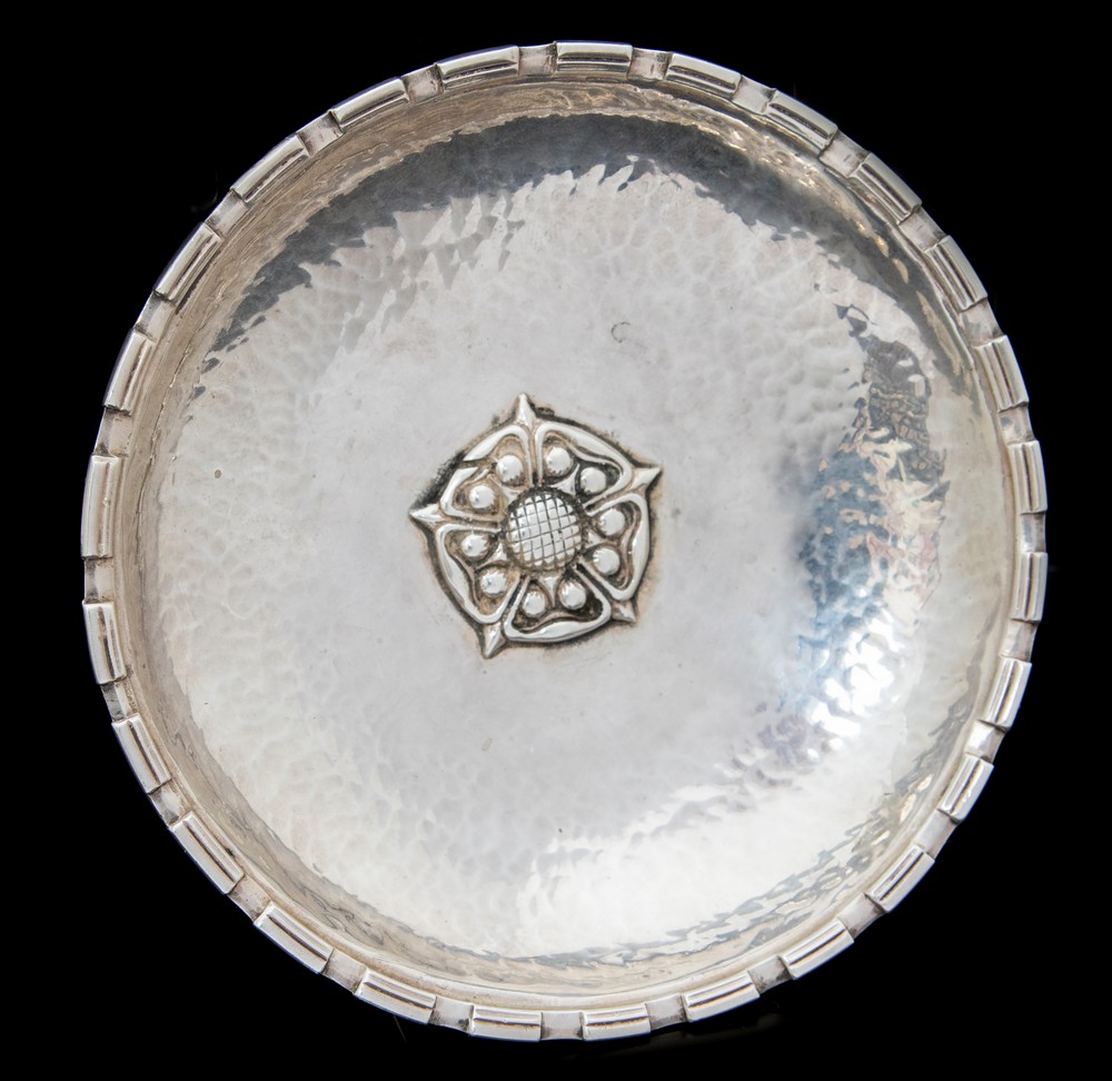 Omar Ramsden, an Arts and Crafts silver dish, shallow, planished form with denticulated fluted rim,