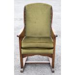 An Arts and Crafts oak and upholstered wing sided armchair, paneled board sides,