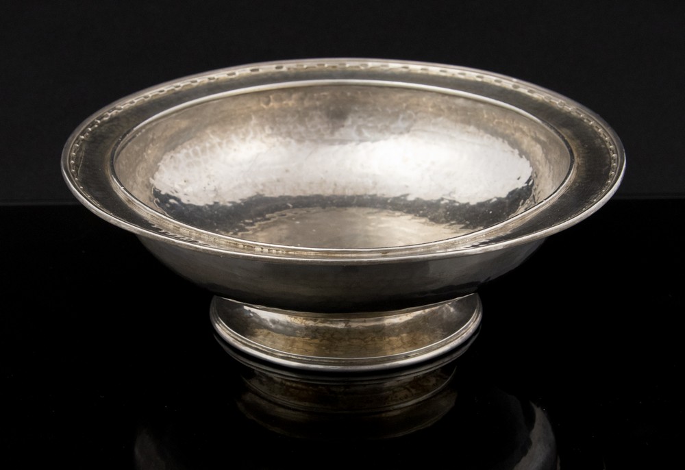 Omar Ramsden, an Arts and Crafts silver bowl with hammered finish, raised on circular pedestal foot,