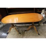 A reproduction elm veneered twin pedestal coffee table