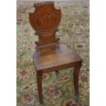 A 19th Century oak hall chair, with a shield shaped back, solid seat,