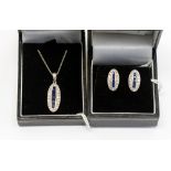 An 18k white gold diamond and sapphire pendant and pair of earrings ensuite,