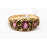 A Victorian gem set 15ct rose gold ring, set with three oval graduated garnets,