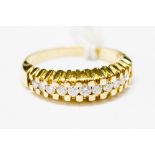 A diamond yellow metal dress ring, eleven small round brilliant cut diamonds, ring size P½,