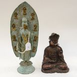 A brass Indian figure of deity standing in front of a plaque depicting nine other deities,