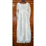 A 1960s wedding dress with short train, long pointed sleeves with metal zips empire style waistline,