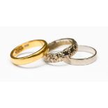 Three gold wedding bands, one 22ct gold, one 18ct white gold with a star pattern,