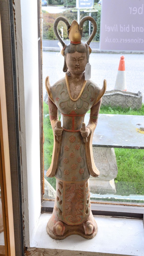 A painted terracotta figure of woman in traditional dress, having two handled head dress,