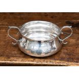 A later Victorian silver porringer, plain body with S-scroll handles,