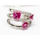 A pink tourmaline and diamond set three split row 18ct white gold band ring,