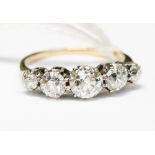 An 18ct gold five stone diamond ring, claw set with five brilliant cut diamonds set in platinum,