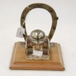 Equestrian interest, a glass ink-well having Jockey cap as cover, sitting on a wood plinth,