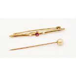 An eighteen carat gold bar brooch, set with a central ruby and two seed pearls, circa 1917/18,